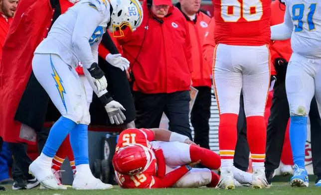 Los Angeles Chargers defensive tackle Justin Eboigbe (92) checks on Kansas City Chiefs quarterback Patrick Mahomes (15) as Chiefs head coach Andy Reid, center, looks on after Mahomes was injured during the second half of an NFL football game, Sunday, Dec. 14, 2025 in Kansas City, Mo. (AP Photo/Reed Hoffmann)