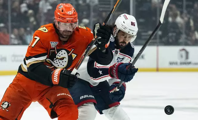 Anaheim Ducks left wing Alex Killorn (17) and Columbus Blue Jackets right wing Kirill Marchenko (86) vie for the puck during the first period of an NHL hockey game, Saturday, Dec. 20, 2025, in Anaheim, Calif. (AP Photo/Kyusung Gong)
