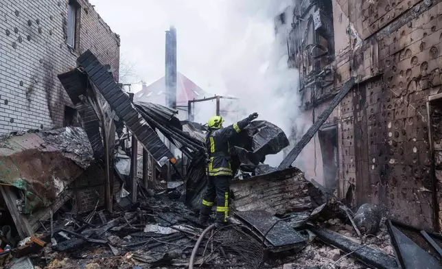 A rescue worker clears the rubble of a house destroyed after a Russian strike on Kyiv, Ukraine, on Saturday, Dec. 27, 2025. (AP Photo/Evgeniy Maloletka)