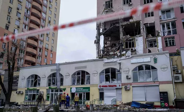 Rescue workers clear the rubble of a residential building which was heavily damaged after a Russian strike on Kyiv, Ukraine, on Saturday, Dec. 27, 2025. (AP Photo/Evgeniy Maloletka)