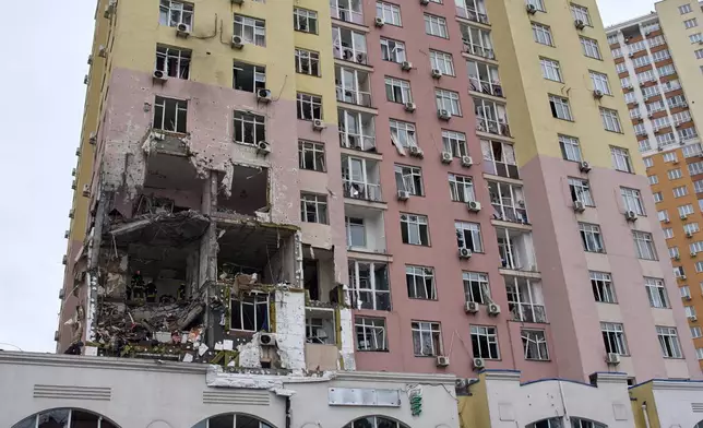 Rescuers work on the scene of a multi-storey apartment building damaged during a Russian massive missile and drone attack in Kyiv, Ukraine, Saturday, Dec. 27, 2025. (AP Photo/Efrem Lukatsky)