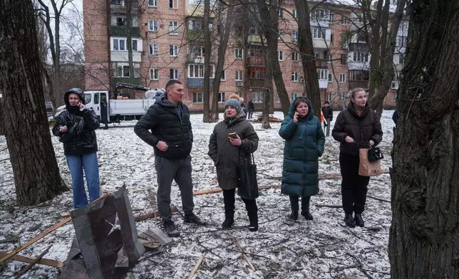 People look at their apartment building damaged after a Russian strike on Kyiv, Ukraine, on Saturday, Dec. 27, 2025. (AP Photo/Evgeniy Maloletka)