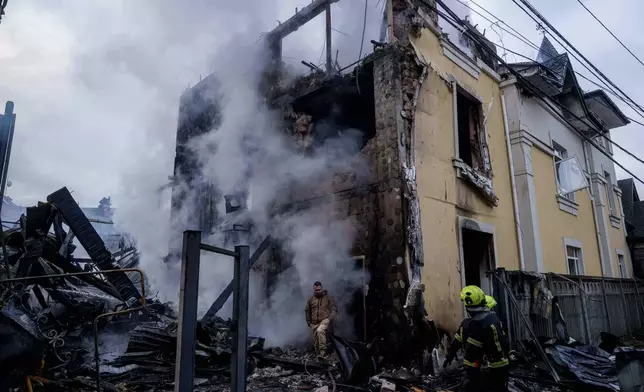 A man walks from a house destroyed after a Russian strike on Kyiv, Ukraine, on Saturday, Dec. 27, 2025. (AP Photo/Evgeniy Maloletka)