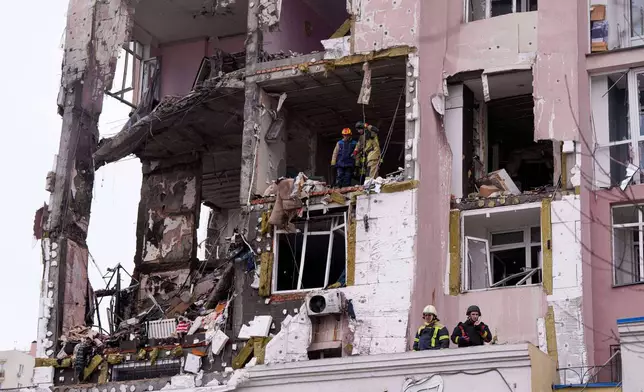 Rescue workers clear the rubble of a residential building which was heavily damaged after a Russian strike on Kyiv, Ukraine, on Saturday, Dec. 27, 2025. (AP Photo/Evgeniy Maloletka)