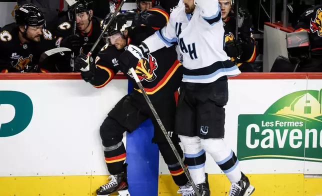 Utah Mammoth's Jack McBain, right, checks Calgary Flames' Blake Coleman during third period NHL hockey action in Calgary on Saturday, Dec. 6, 2025. (Jeff McIntosh/The Canadian Press via AP)