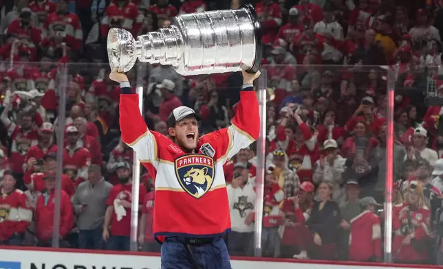 FILE - Florida Panthers center Eetu Luostarinen raises the Stanley Cup trophy after defeating the Edmonton Oilers in Game 6 of the NHL hockey Stanley Cup Final June 17, 2025, in Sunrise, Fla. (AP Photo/Lynne Sladky, File)
