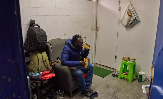 Yankuba Touray, from Gambia, eats his breakfast inside an abandoned school in Badalona, near Barcelona, Spain, Tuesday, Dec. 16, 2025, where hundreds of migrants have been occupying the building.(AP Photo/Emilio Morenatti)
