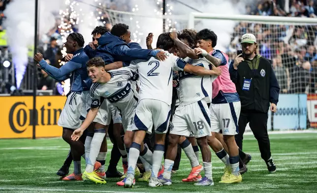 Vancouver Whitecaps' Mathias Laborda (2) celebrates with his teammates after defeating Los Angeles FC during penalty kicks in the MLS Western Conference semifinal playoff soccer match, in Vancouver, British Columbia, Saturday, Nov. 22, 2025. (Ethan Cairns/The Canadian Press via AP)