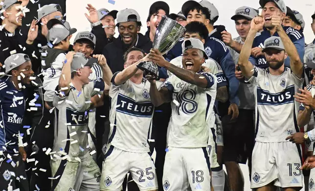 Vancouver Whitecaps midfielder Ryan Gauld (25) and defender Édier Ocampo (18) hold up the trophy after winning the MLS Western Conference final soccer match against San Diego FC, Saturday, Nov. 29, 2025, in San Diego. (AP Photo/Denis Poroy)
