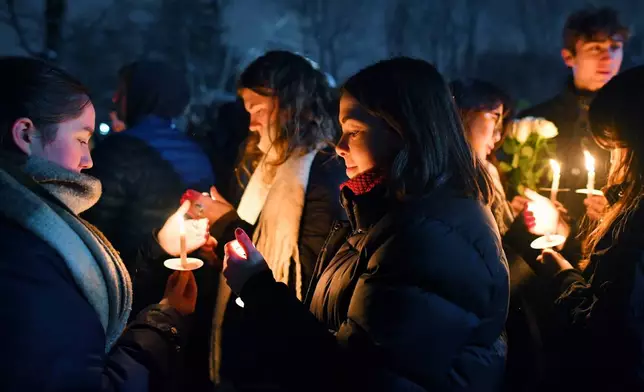 People hold candles during a vigil, Sunday, Dec. 14, 2025, in Providence, R.I., for the victims of Saturday's shooting on the campus of Brown University. (AP Photo/Steven Senne)