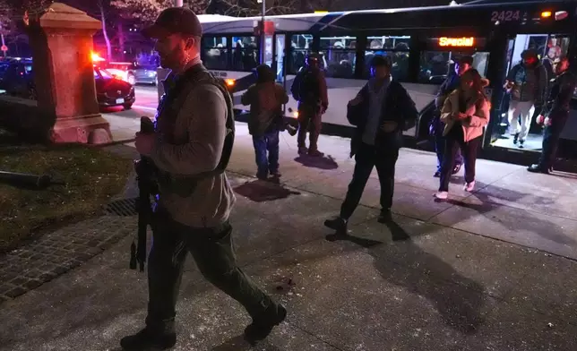 Students are escorted by law enforcement officers to a building at Brown University after a shooting, Saturday, Dec. 13, 2025, in Providence, R.I.. (AP Photo/Charles Krupa)