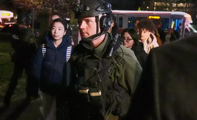 Students are escorted by law enforcement officers to a building at Brown University after a shooting, Saturday, Dec. 13, 2025, in Providence, R.I.. (AP Photo/Charles Krupa)