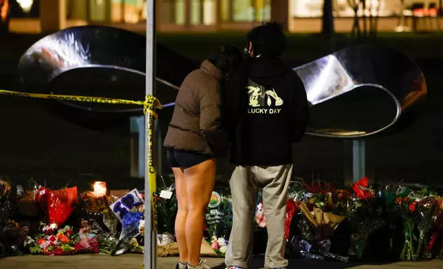 People visit a memorial outside of Brown University's Barus and Holley building in Providence, R.I., Wednesday, Dec. 17, 2025. (Lily Speredelozzi/The Sun Chronicle via AP)