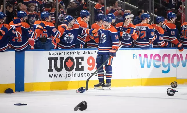 Edmonton Oilers' Zach Hyman (18) celebrates a hat trick against the Detroit Red Wings during the third period of an NHL hockey game in Edmonton on Thursday, Dec. 11, 2025. (Jason Franson/The Canadian Press via AP)
