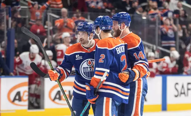 Edmonton Oilers' Zach Hyman (18), Evan Bouchard (2) and Mattias Ekholm (14) celebrate a goal against the Detroit Red Wings during second period NHL action, in Edmonton on Thursday, Dec. 11, 2025. (Jason Franson/The Canadian Press via AP)