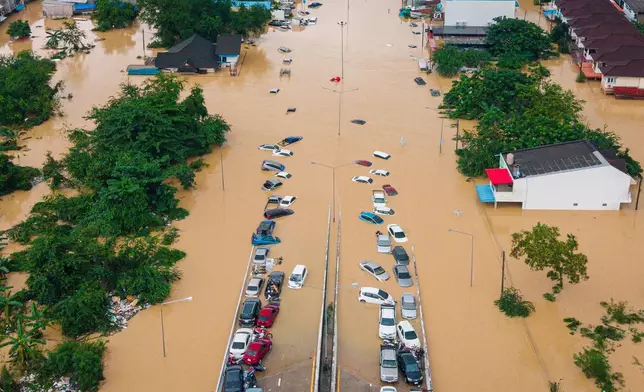 FILE - Cars and houses are submerged in floodwaters in Songkhla province, southern Thailand, on Nov. 26, 2025. (AP Photo/Arnun Chonmahatrakool, File)