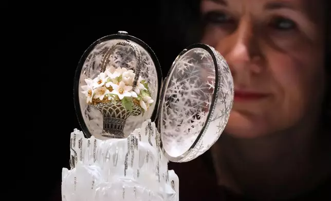 Head of Department Margo Organesian looks towards the Winter Egg by Faberge as it is displayed at Christie's auction rooms in London, Thursday, Nov. 27, 2025, it is expected to sell for in excess of 20 million UK Pounds when it is auctioned on Dec. 2. (AP Photo/Kirsty Wigglesworth)