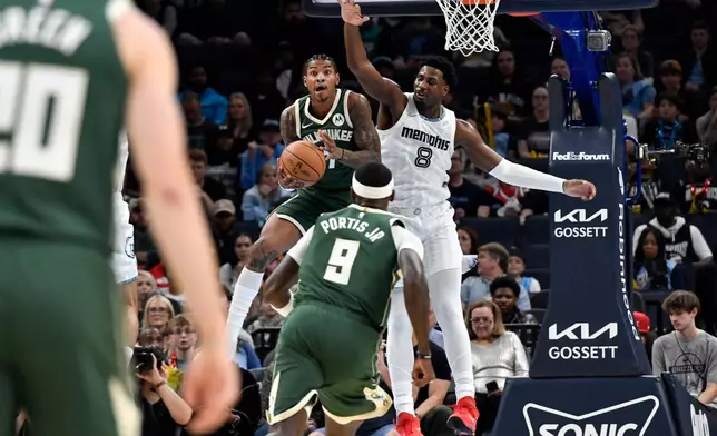 Milwaukee Bucks guard Kevin Porter Jr. handles the ball against Memphis Grizzlies forward Jaren Jackson Jr. (8) in the first half of an NBA basketball game, Friday, Dec. 26, 2025, in Memphis, Tenn. (AP Photo/Brandon Dill)