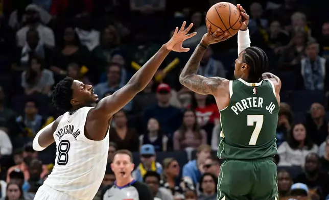 Milwaukee Bucks guard Kevin Porter Jr. (7) shoots against Memphis Grizzlies forward Jaren Jackson Jr. (8) in the first half of an NBA basketball game, Friday, Dec. 26, 2025, in Memphis, Tenn. (AP Photo/Brandon Dill)