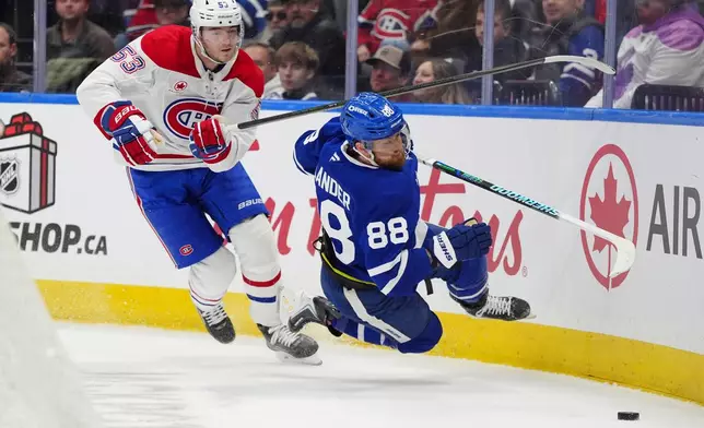 Montréal Canadiens defenceman Noah Dobson (53) picks up a penalty for tripping Toronto Maple Leafs right wing William Nylander (88) during second period NHL hockey action in Toronto on Saturday, Dec. 6, 2025. (Frank Gunn/The Canadian Press via AP)