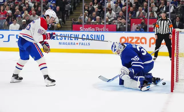 Montréal Canadiens left wing Alexandre Texier (85) scores the winning goal against Toronto Maple Leafs goaltender Dennis Hildeby (35) during shootout NHL hockey game action in Toronto, Saturday, Dec. 6, 2025. (Frank Gunn/The Canadian Press via AP)