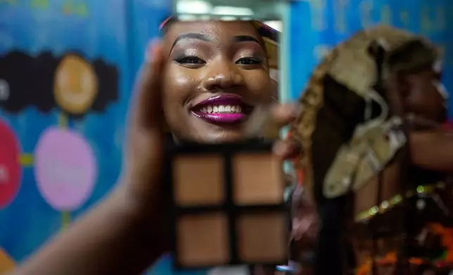 A model is reflected in a mirror applying makeup during the Mr. and Mrs. Kibera leadership contest held on International Youth Day in Nairobi, Kenya, Aug. 12, 2025. (AP Photo/Brian Inganga, File)
