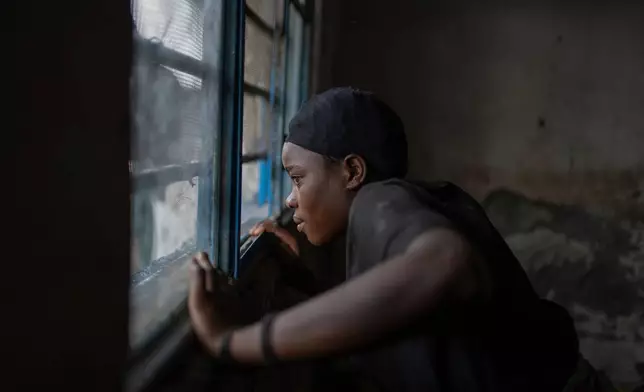 Riziki Olinde, 26, looks out from the window of a school where she found shelter after her soldier husband was sent to Rumangabo for mixing and integration into the rebel M23 forces, Feb. 18, 2025, in Goma, eastern Congo. (AP Photo/Moses Sawasawa, File)