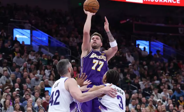 Los Angeles Lakers guard Luka Doncic (77) shoots over Utah Jazz forward Kevin Love (42) and guard Keyonte George (3) during the second half of an NBA basketball game, Thursday, Dec. 18, 2025, in Salt Lake City. (AP Photo/Rob Gray)