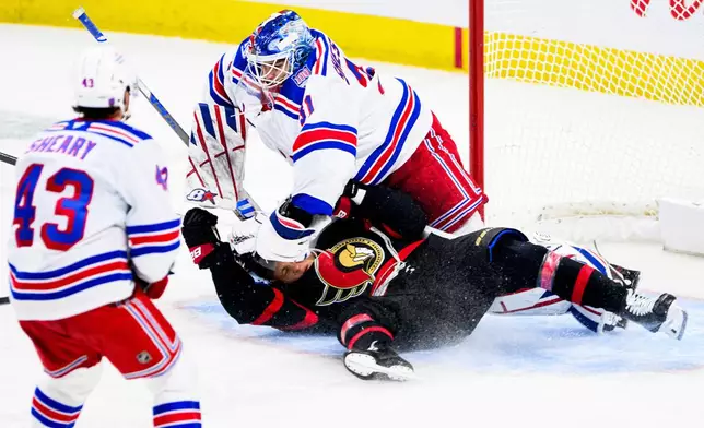 Ottawa Senators' Tim Stutzle (18) crashes into New York Rangers goaltender Igor Shesterkin (31) on a breakaway during third period NHL hockey action in Ottawa, on Thursday, Dec. 4, 2025. (Spencer Colby/The Canadian Press via AP)