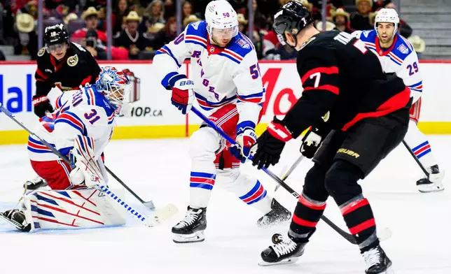 New York Rangers' Will Cuylle (50) and Ottawa Senators' Brady Tkachuk (7) fight for control of the puck during second-period NHL hockey game action in Ottawa, Ontario, Thursday, Dec. 4, 2025. (Spencer Colby/The Canadian Press via AP)