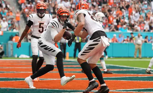 Cincinnati Bengals tight end Mike Gesicki, front left, celebrates after his touchdown with wide receiver Andrei Iosivas (80) during the second half of an NFL football game against the Miami Dolphins, Sunday, Dec. 21, 2025, in Miami Gardens, Fla. (AP Photo/Rebecca Blackwell)