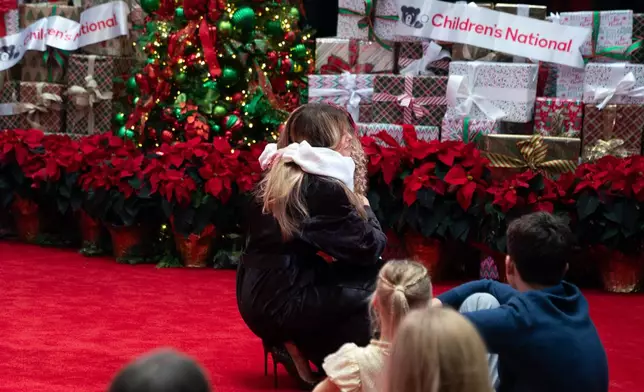 First lady Melania Trump hugs Faith Hinkle, a 5-year-old Children's National Hospital patient, Friday, Dec. 5, 2025, in Washington. (AP Photo/Allison Robbert)
