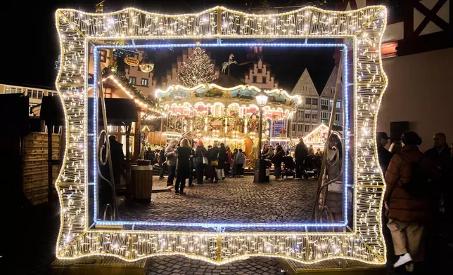FILE - An illuminated giant frame is set up at the Christmas market for visitors to make souvenir photos of themselves, in Frankfurt, Germany, Nov. 25, 2025. (AP Photo/Michael Probst, File)