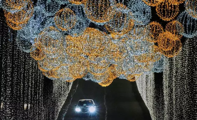 FILE - Holiday lights adorn a roadway at the Nemacolin Woodlands Resort on light-up night in Farmington, Pa., Nov. 28, 2025. (AP Photo/Gene J. Puskar, File)