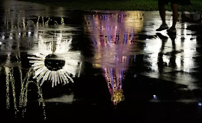 FILE - Holiday lights are reflected in a rain-soaked plaza in Makati, Philippines, Dec. 9, 2025. (AP Photo/Aaron Favila, File)