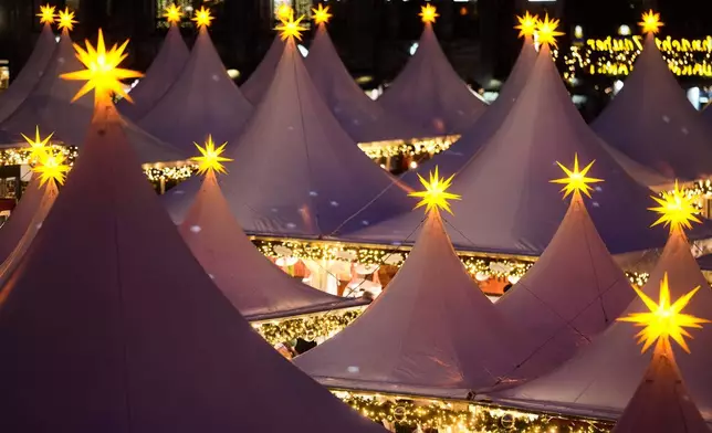 FILE - Lights illuminate the Christmas market at the Gendarmenmarkt square in Berlin, Germany, Nov. 24, 2025. (AP Photo/Markus Schreiber, File)