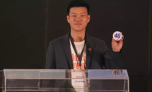 People's Party Natthaphong Ruengpanyawut shows his number after a drawing at a candidate registration in Bangkok, Thailand, Sunday, Dec. 28, 2025. (AP Photo/Sakchai Lalit)