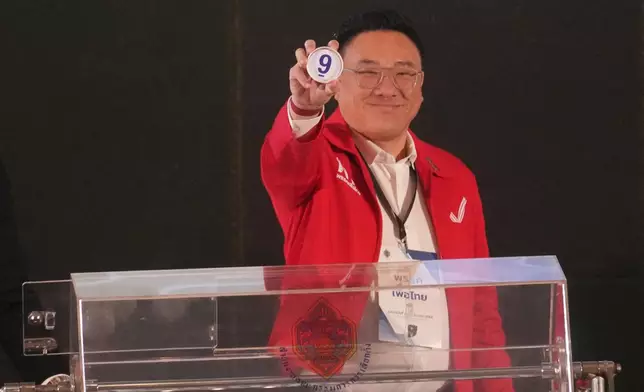 Pheu Thai Party's Julapun Amornviva shows his number after a drawing at a candidate registration in Bangkok, Thailand, Sunday, Dec. 28, 2025. (AP Photo/Sakchai Lalit)