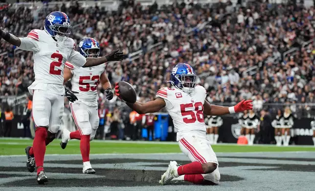 New York Giants linebacker Bobby Okereke (58) celebrates his interception with cornerback Deonte Banks (2) and linebacker Darius Muasau (53) during the first half of an NFL football game against the Las Vegas Raiders Sunday, Dec. 28, 2025, in Las Vegas. (AP Photo/John Locher)