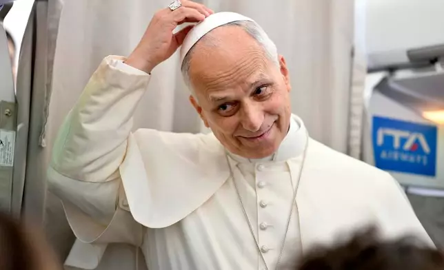 Pope Leo XIV talks to reporters aboard an airplane as he returns from a six-day visit to Turkey and Lebanon, Tuesday, Dec. 2, 2025. (Alessandro Di Meo/Pool Photo via AP)
