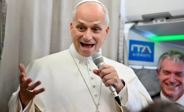 Pope Leo XIV talks to reporters aboard an airplane as he returns from a six-day visit to Turkey and Lebanon, Tuesday, Dec. 2, 2025. (Alessandro Di Meo/Pool Photo via AP)