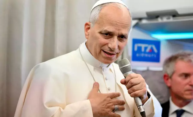 Pope Leo XIV talks to reporters aboard an airplane as he returns from a six-day visit to Turkey and Lebanon, Tuesday, Dec. 2, 2025. (Alessandro Di Meo/Pool Photo via AP)
