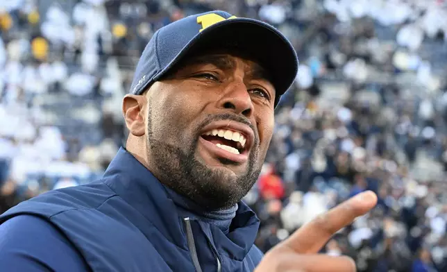 FILE - Michigan acting head coach Sherrone Moore celebrates a 24-15 win over Penn State following an NCAA college football game, Saturday, Nov. 11, 2023, in State College, Pa. (AP Photo/Barry Reeger, File)