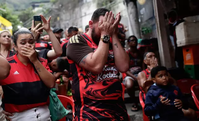 Flamengo fans react after their team lost the FIFA Intercontinental Cup final soccer match against Paris Saint-Germain in Qatar, in the Rocinha favela of Rio de Janeiro, Wednesday, Dec. 17, 2025. (AP Photo/Bruna Prado)