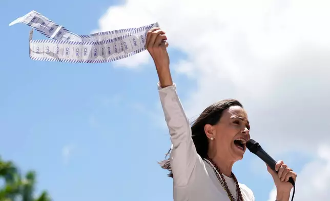 FILE - Opposition leader Maria Corina Machado displays vote tally sheets during a protest against the reelection of President Nicolas Maduro one month after the disputed presidential vote which she says the opposition won by a landslide, in Caracas, Venezuela, Wednesday, Aug. 28, 2024. (AP Photo/Ariana Cubillos, file)