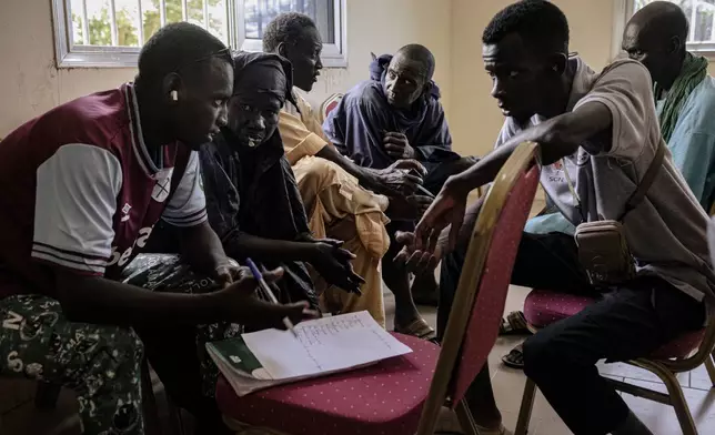 Peul, herders who have traditionally raised animals across lands from Senegal to Nigeria, gather at a workshop organized by a local association to raise awareness of environmental issues related to transhumance, moving livestock from one grazing area to another, in Labgar, Louga region, Senegal, Oct. 16, 2025. (AP Photo/Andrea Ferro)
