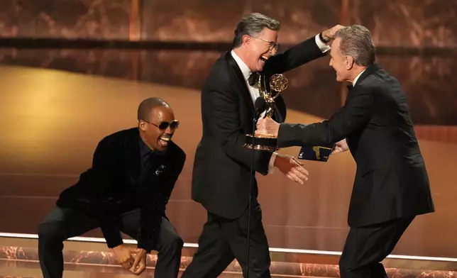 Bryan Cranston, right, presents the award for outstanding talk series to Stephen Colbert for "The Late Show with Stephen Colbert" during the 77th Primetime Emmy Awards at the Peacock Theater in Los Angeles, Sept. 14, 2025. (AP Photo/Chris Pizzello, File)
