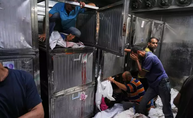Bodies of Palestinians, who were killed while trying to reach aid trucks entering northern Gaza through the Zikim crossing with Israel, are prepared for burial at the morgue of Shifa Hospital in Gaza City on July 31, 2025. (AP Photo/Jehad Alshrafi, File)