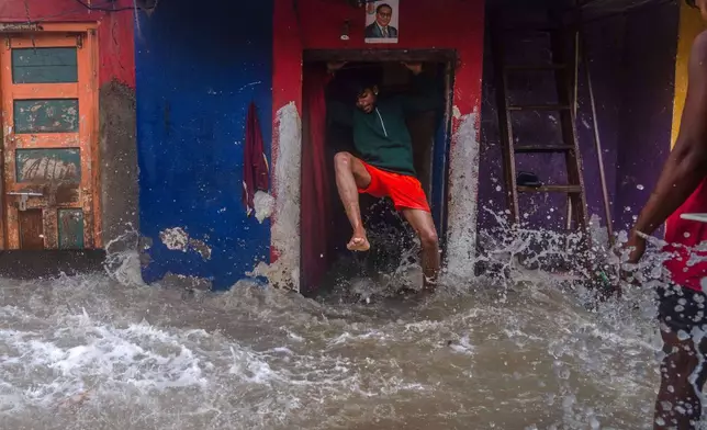 A man jumps as waves lash his house during high tide on the shore of the Arabian Sea in Mumbai, India, on June 25, 2025. (AP Photo/Rafiq Maqbool, File)
