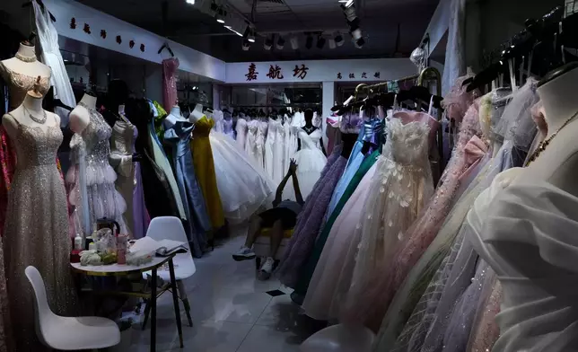 Dresses hang at a garment store in Beijing on July 27, 2025. (AP Photo/Mahesh Kumar A., File)